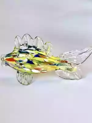 Popularna w latach 60-70 tych szklana mała rybka.  Rybka wykonana ręcznie tzw techniką Mille Fiori z bezbarwnego szkła w które wtopiono barwne pręty,  tworząc wielobarwną połyskującą taflę. Ryba jest w bardzo rzadkim,  małym rozmiarze.  Przeważnie szklane rybki z tamtego okresu pochodzą z 