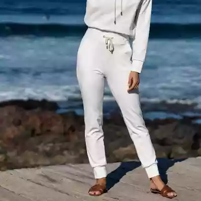 Niezwykle kobiece spodnie dresowe z linii Basic w kolorze ecru ze złotymi wykończeniami.      W porównaniu do naszych bestsellerowych dresów Comfty,  zamiast taśm rypsowych spodnie posiadają sznurki ściągające ze 100% bawełny.       Dresy Basic zostały stworzone z myślą o bardziej ekologic